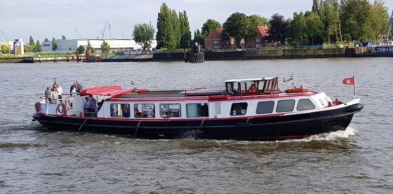 Kleines Partyboot mit rot-weißem Rumpf auf der Elbe in Hamburg